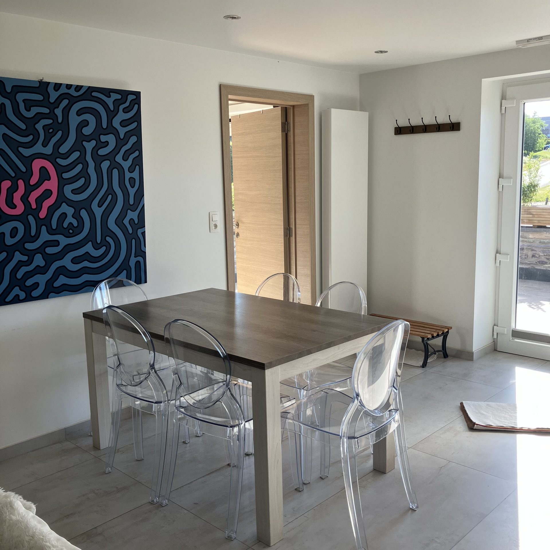 Coin repas lumineux avec grande table et chaises design transparentes