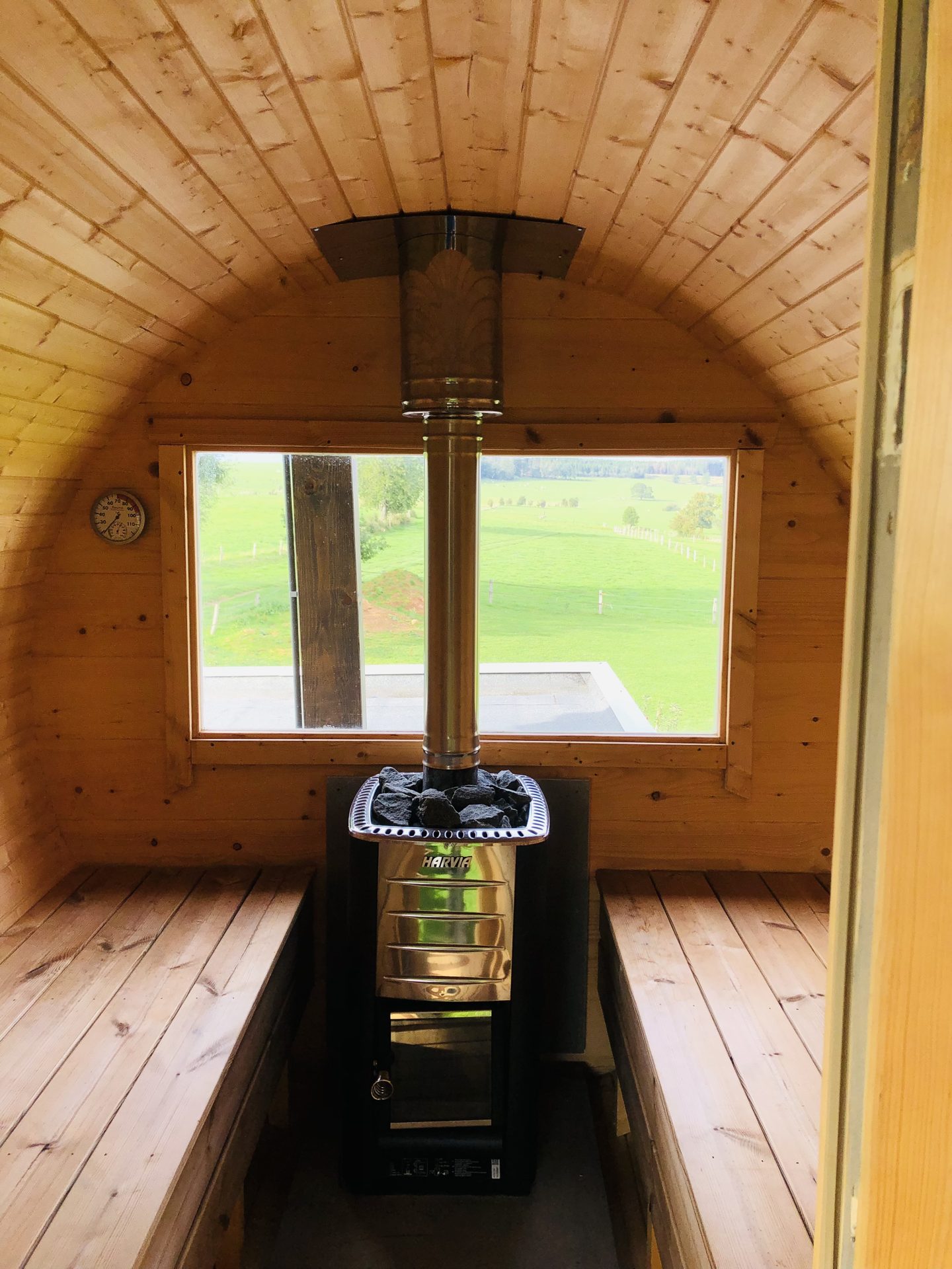 Intérieur du sauna tonneau avec vue sur les prairies