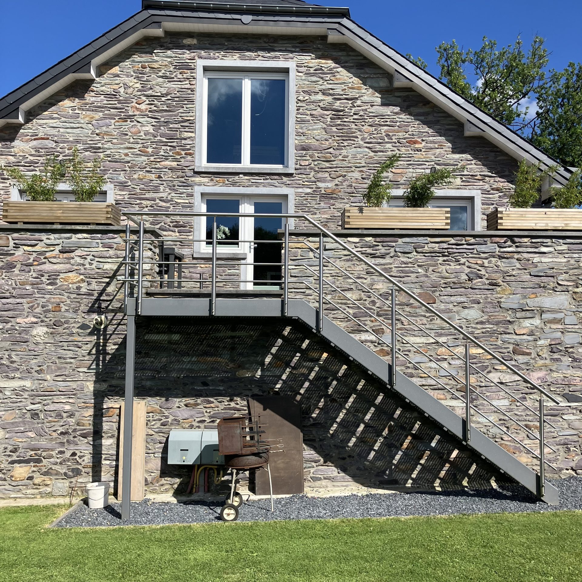 Accès à l’appartement par l’escalier extérieur, le long de la façade en pierre